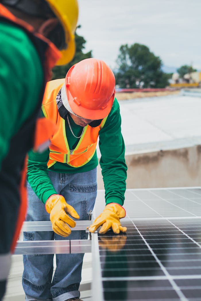 about-us Worker in safety gear installing solar panels on a rooftop.